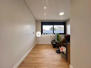Hall de entrada com piso de madeira e janela.