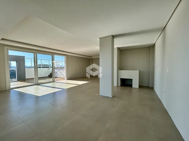 Ambiente interno de uma sala ampla com portas de vidro que dão para uma vista externa.