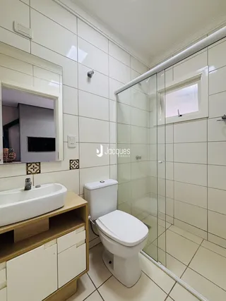 Foto de um banheiro com piso de cerâmica e box de vidro.