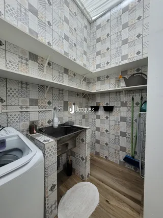 Imagem de uma cozinha com revestimento de azulejos e piso de madeira.