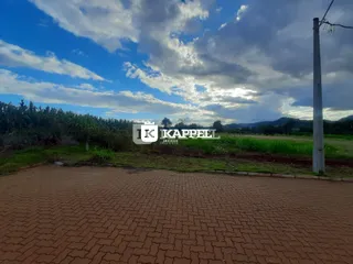 Vista de um terreno com piso de tijolos avermelhados e vegetação ao fundo em Lajeado.