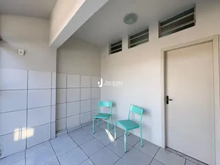 Interior de um ambiente com paredes brancas e piso de cerâmica.