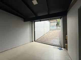 Vista de um ambiente interno com acesso a uma área externa pavimentada.