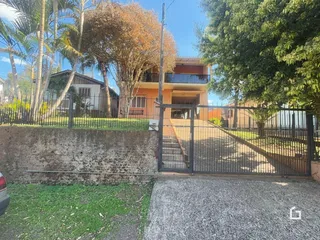 Fachada de uma residência em Lajeado, Brasil, com cerca e portão de ferro.