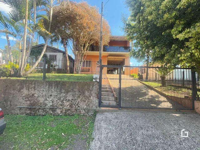 Fachada de uma residência em Lajeado, Brasil, com cerca e portão de ferro.
