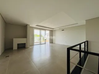 Ambiente interno amplo com piso de porcelanato e portas de vidro.