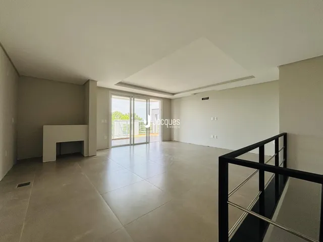 Ambiente interno amplo com piso de porcelanato e portas de vidro.