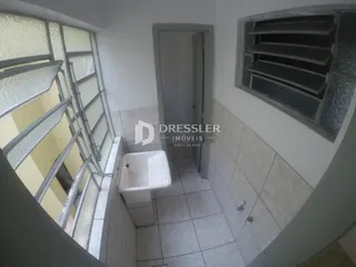 Vista interna de um banheiro com piso de cerâmica e janela.
