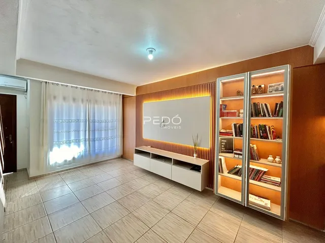 Ambiente interno de uma sala com piso de cerâmica e estantes em um imóvel no Brasil.