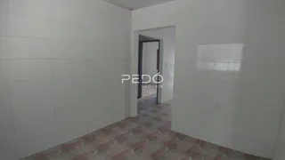 Hall de entrada com paredes brancas e piso de terracota em um imóvel no Brasil.
