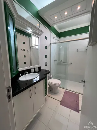 Um banheiro com revestimento branco e bancada preta é exibido na propriedade.