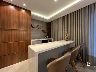 Ambiente interno moderno com armários de madeira e bancada em sala de estar.