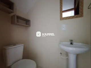 Banheiro com vaso sanitário e pia branca.