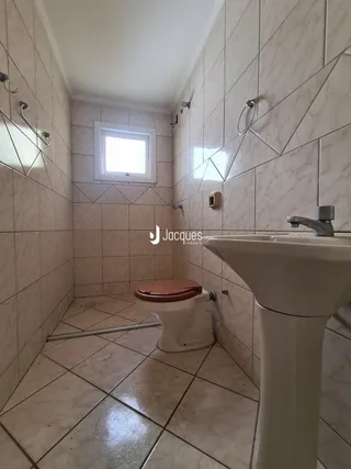 Interior de um banheiro com revestimento de cerâmica nas paredes e piso.