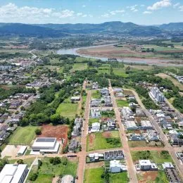 Vista aérea de uma área residencial com casas e vegetação ao redor.
