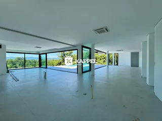 Uma sala ampla com grandes janelas que oferecem uma vista para a paisagem.