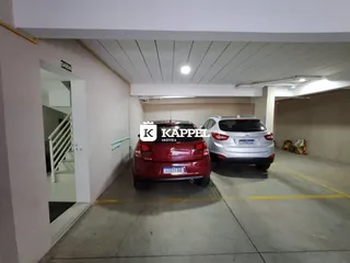 Foto de uma área de garagem com dois veículos estacionados.