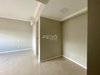 Vista interna de um ambiente com paredes brancas e piso de cerâmica.