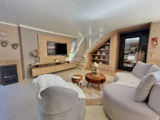 Sala de estar moderna com sofá e decoração de madeira.