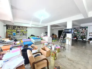 Imagem de um espaço interno amplo com materiais de armazenamento e móveis.