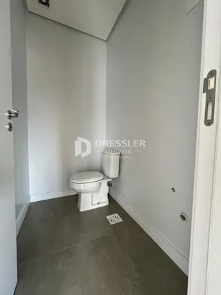 Foto de um ambiente interno com vaso sanitário branco e piso cinza.