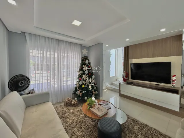 Sala de estar moderna com decoração de Natal e grandes janelas.