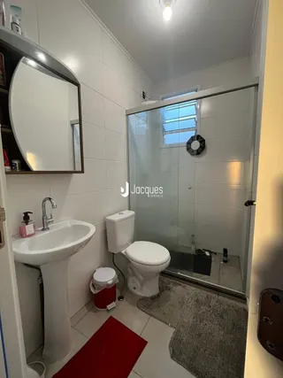 Foto de um banheiro interno com pia e box de vidro.