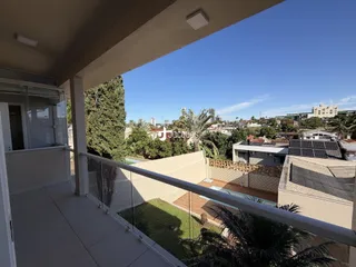 Vista da varanda com vista para a paisagem verde e a cidade ao longe.