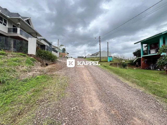 Vista externa de uma rua de terra em uma área residencial em Lajeado, com casas ao lado.