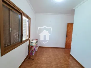 Parede interna de um cômodo com janela de madeira e porta de madeira.