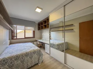 Quarto com duas camas e armário em um apartamento no Brasil.