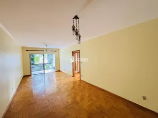 Sala de estar com piso de madeira e porta de vidro que dá para o exterior.