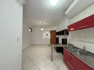 Vista interna de uma cozinha com armários vermelhos e piso de cerâmica clara.