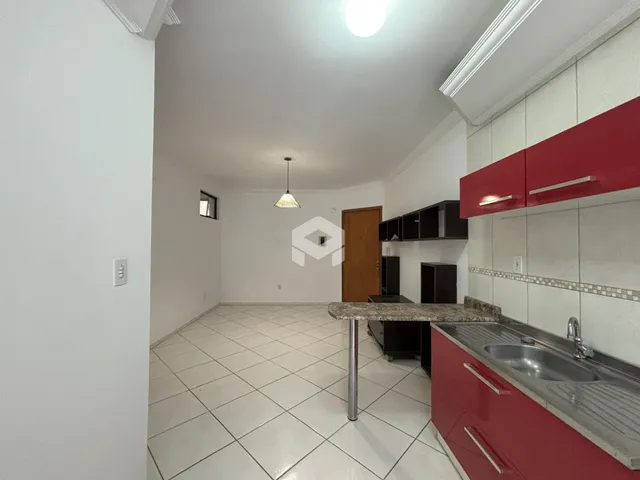 Vista interna de uma cozinha com armários vermelhos e piso de cerâmica clara.