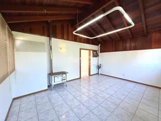 A foto mostra o interior de uma sala com piso de cerâmica e paredes de madeira.