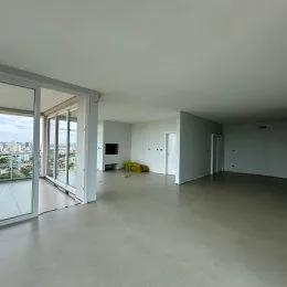 Ambiente interno amplo com paredes brancas e piso claro.