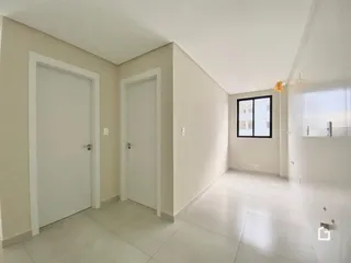 Hall de entrada com portas brancas e piso claro.