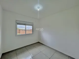Vista interna de um cômodo com piso de cerâmica e janela.