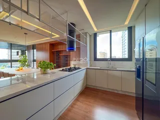 Cozinha moderna com grandes janelas e vista da cidade.