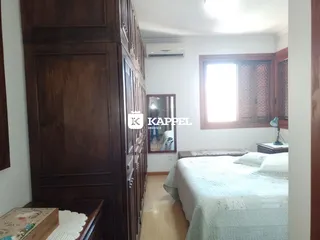 Quarto com cama e armário de madeira escura.