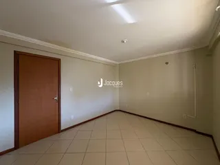 Corredor interno com piso de cerâmica claro.