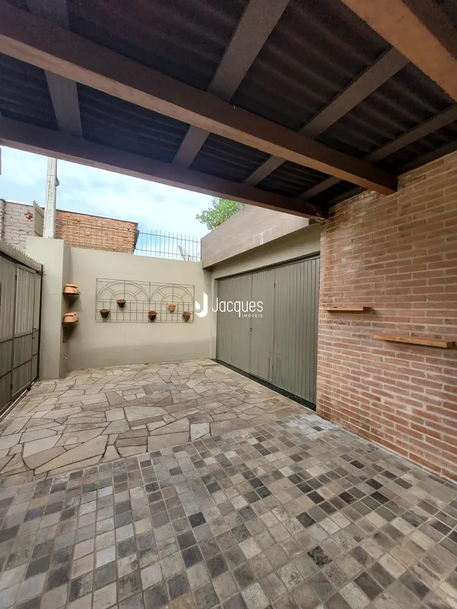 Fachada externa de uma propriedade com piso de pedra e garagem.