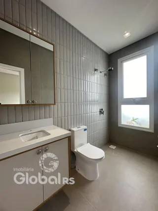 Foto de um banheiro interno com revestimento de azulejo cinza.