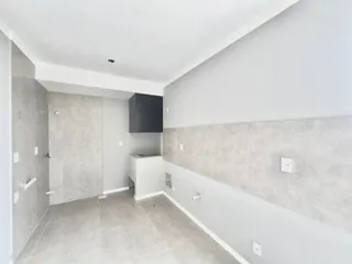 Foto de um corredor interno com revestimento de parede cinza claro e piso de porcelanato.