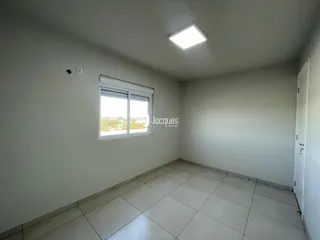 Uma sala interna com piso de cerâmica e janela.