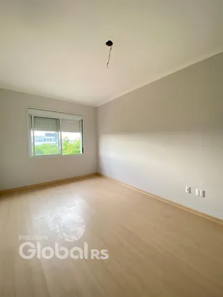Sala de estar com piso de madeira clara e janela.