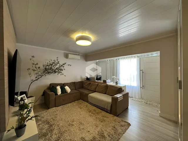 Sala de estar com sofá e piso de madeira clara.