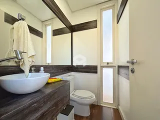 Foto de um banheiro moderno com bancada e vaso sanitário.