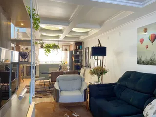 Sala de estar com sofá grande e iluminação clara em um ambiente moderno.