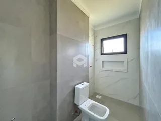 Foto de um banheiro moderno com revestimento de mármore claro.